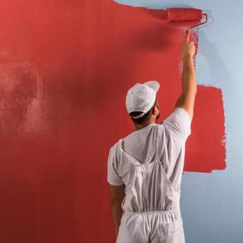 Pracovník malující pokoj na červeno